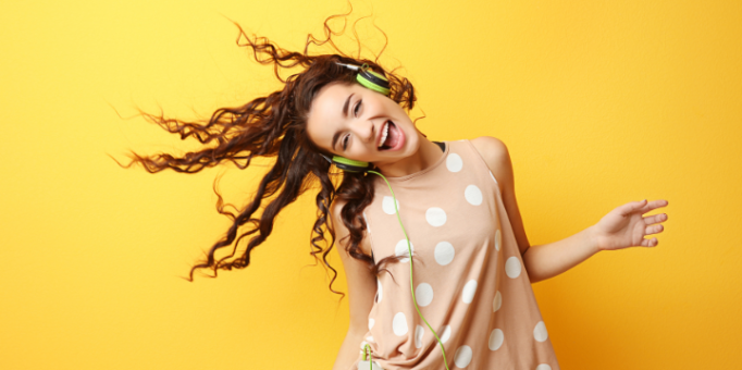 Chica escuchando música con cascos y sonriendo